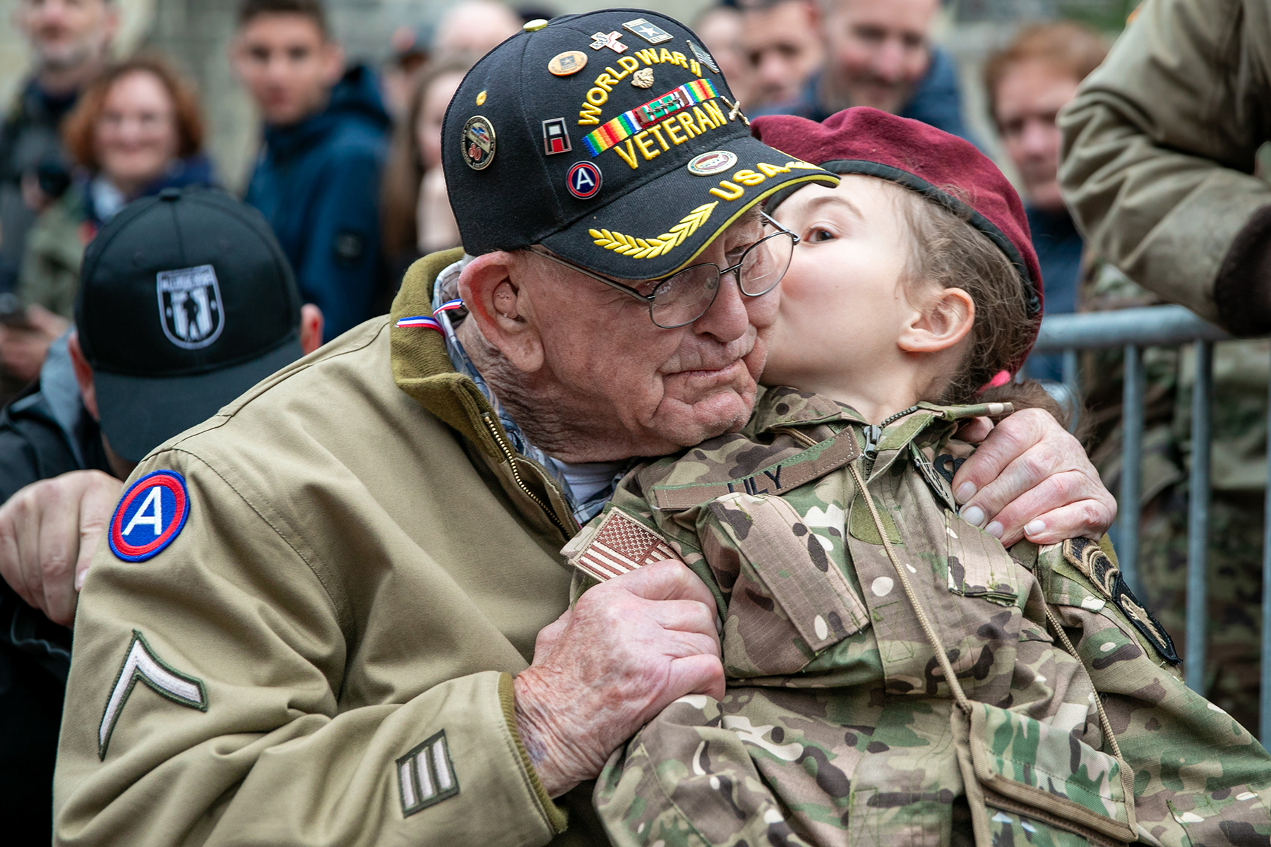 World War II veteran Dennis Boldt, who landed on Utah Beach during Normandy invasion, is kissed by French girl before concert in Sainte-Mère-Église commemorating town’s liberators, June 4, 2024 (U.S. Army/Katherine Sibilla
